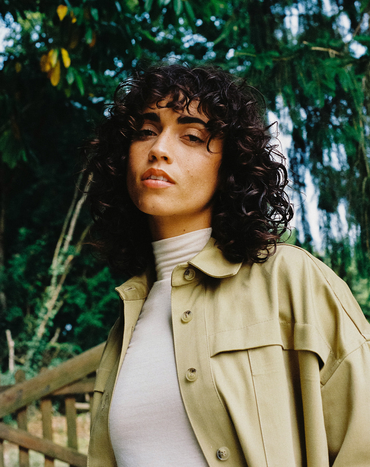 femme avec un col roulé blanc avec une sur-chemise khaki clair