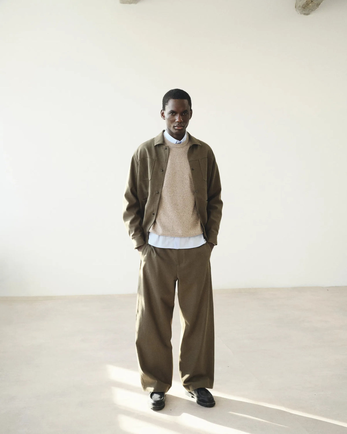 Silhouette homme taupe et beige dans la lumière du studio