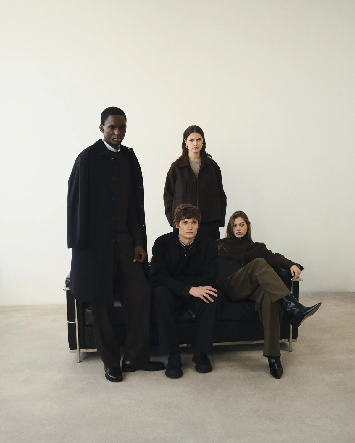 Quatre silhouettes AW26 réunies autour du canapé