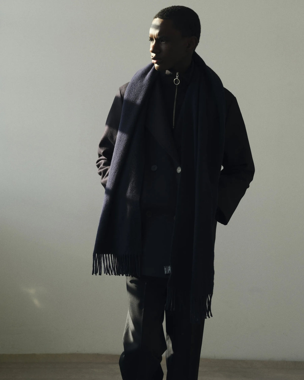 Silhouette homme en long manteau noir et écharpe