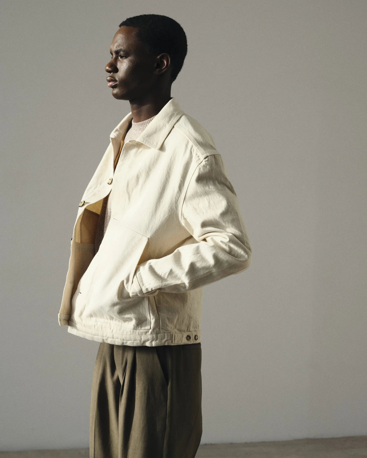 Silhouette homme en veste écrue et maille taupe