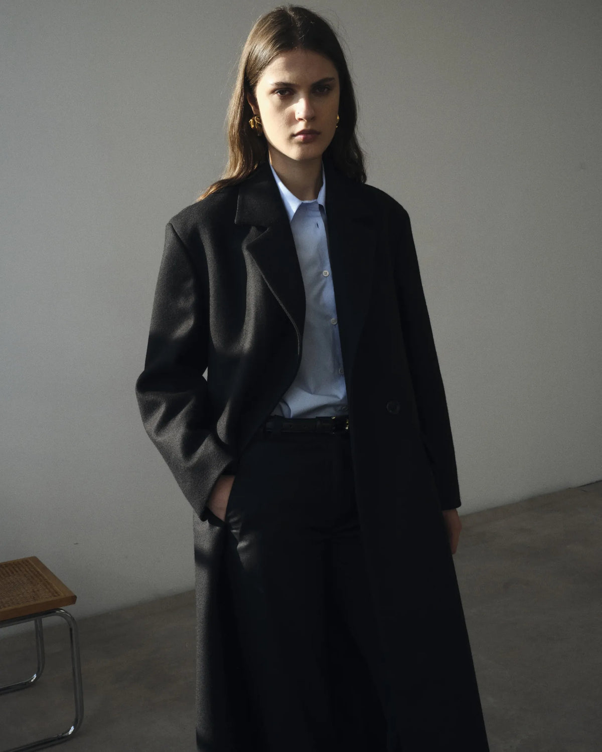 Silhouette femme en manteau noir et chemise bleu pâle