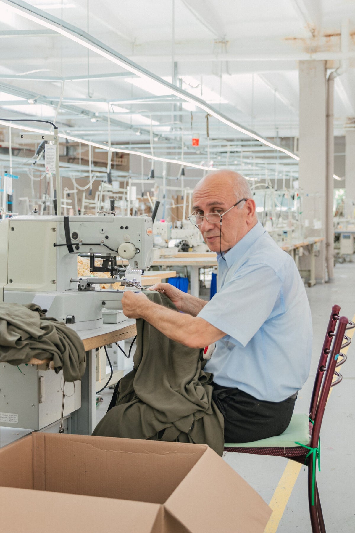Un couturier assemble un vêtement à la machine dans un atelier roumain.